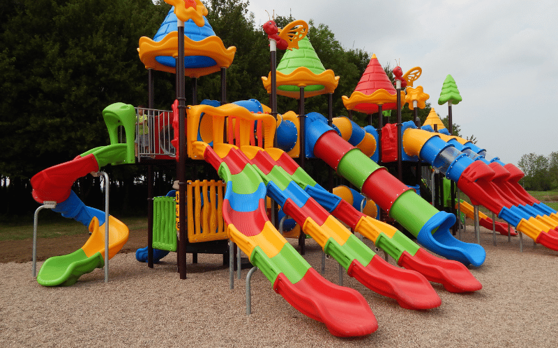 Inspect the surface of the playground plastic slide for cracks.