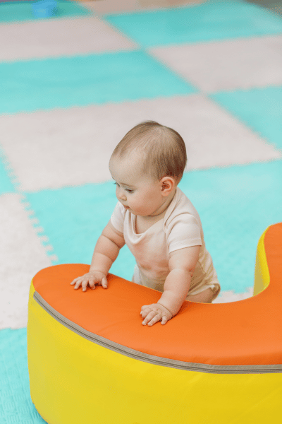 Baby learning to stand with soft play block. Early development Baby learning to stand with soft play block. Early development